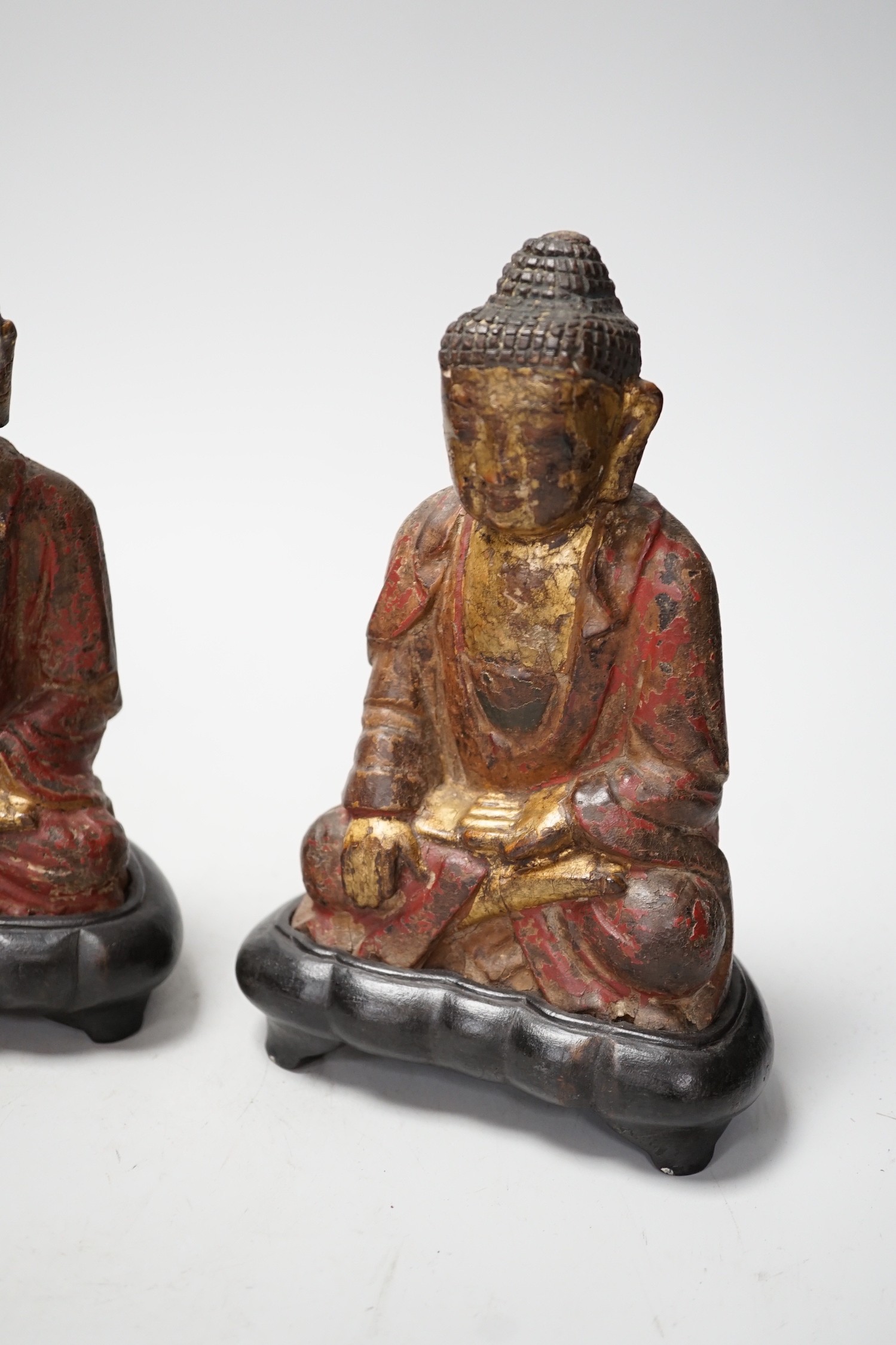 A set of three Chinese polychrome lacquered wood seated figures of Buddha, 19cm